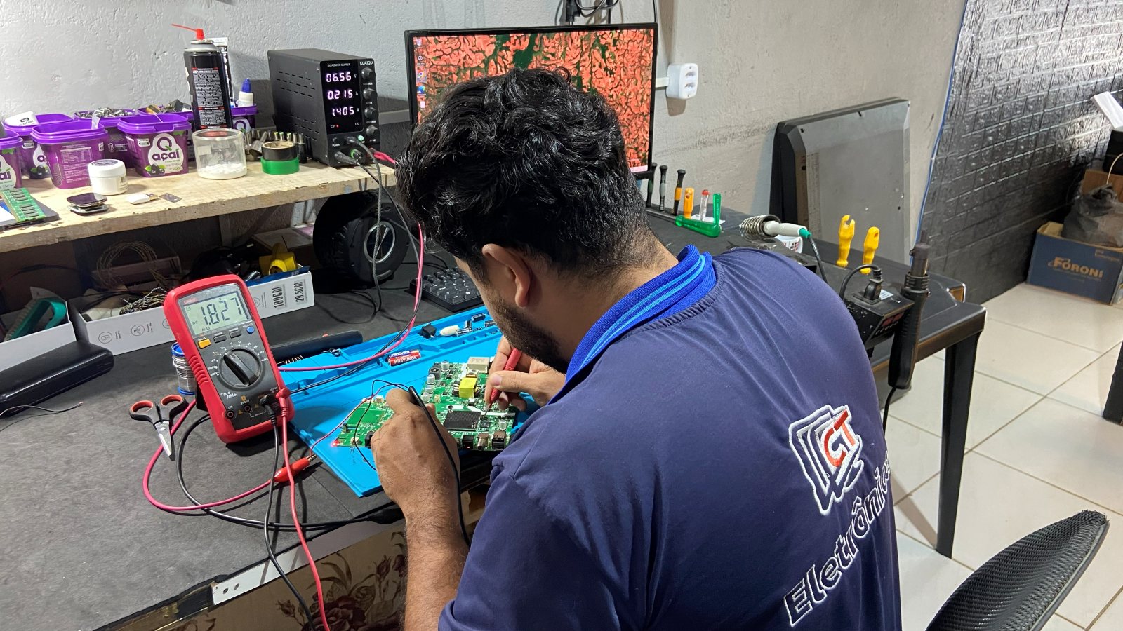 Técnico da CT Eletrônica testando componentes com multímetro